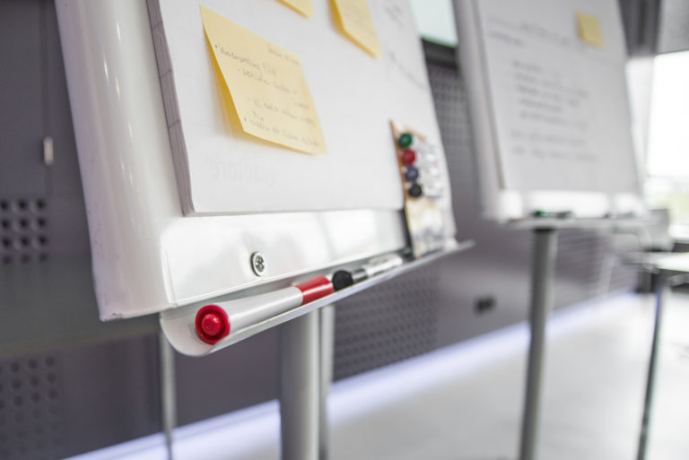 Two whiteboards with yellow sticky notes